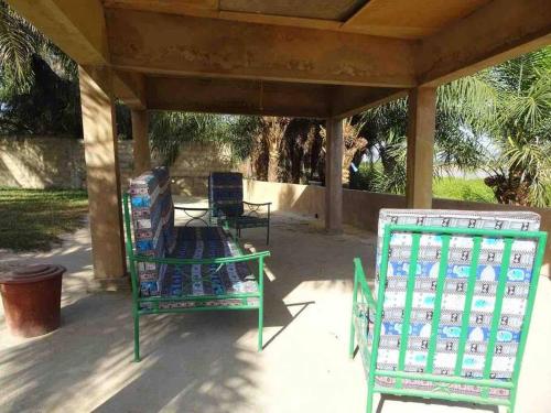 two lawn chairs sitting under a covered porch at Villa La Mangrove à Cap Cap Skirring in Cap Skirring