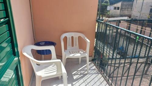 two white chairs sitting on a balcony at La Casa Dei Nonni in Naples