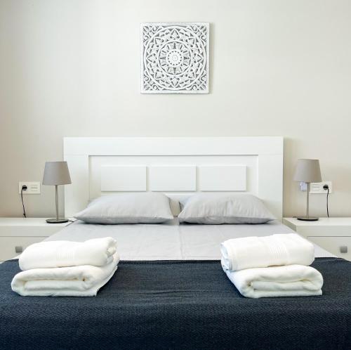 een witte slaapkamer met 2 witte handdoeken op een bed bij Dunas de Marivilla by Spain2home in Torrox