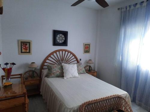 um quarto com uma cama e uma janela em Amplio apartamento en La Barrosa em Novo Sancti Petri