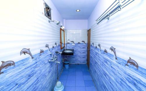 a bathroom with dolphins painted on the wall at Pearl Park Beach Resort Private Limited in Port Blair