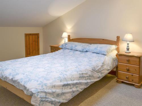 a bedroom with a large bed and two night stands at Dairy Cottage - Ukc3735 in Bawdeswell