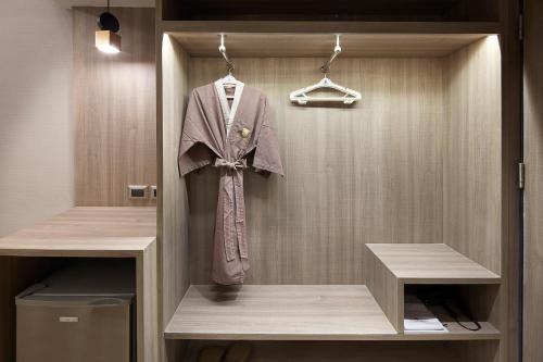 a dressing room with a robe hanging on a wall at Grace Hotel in Bangkok