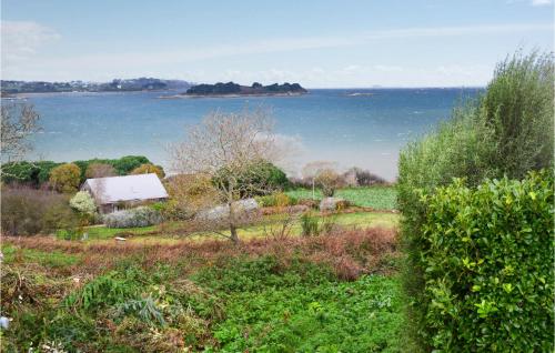 a field with a house and the ocean in the background at 3 Bedroom Nice Home In Kerbors in Kerbors