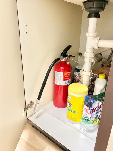 a red fire extinguisher sitting on a shelf under a sink at Golf Front SFH, 3 BR, 2 BA, 4 beds, sleep 6 on Pinehurst #6 in Pinehurst