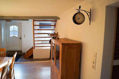 a room with a clock on the wall and a table at Ferienhaus-Abendsonne-Familie-Sikora in Fehmarn