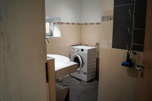 a bathroom with a washing machine and a sink at Ferienhaus-Abendsonne-Familie-Sikora in Fehmarn