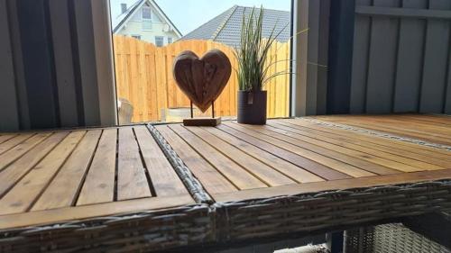 a wooden deck with a heart on a fence at Ferienhaus-Abendsonne-Familie-Sikora in Fehmarn