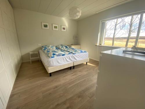 1 dormitorio con 1 cama en una habitación con ventana en Golden Circle private Farmhouse with hot tub, en Selfoss