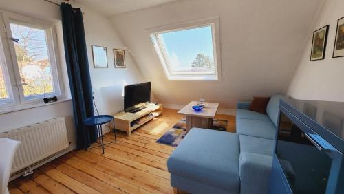 a living room with a blue couch and a tv at Ferienwohnung Am Wasserturm in Plau am See