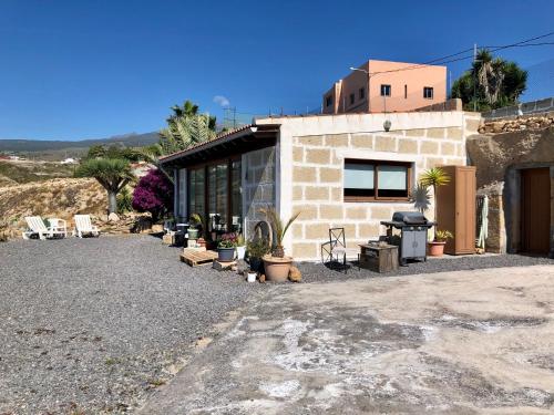 uma pequena casa de tijolos com plantas e uma grelha em Casa Cueva - L&L em Santa Cruz de Tenerife