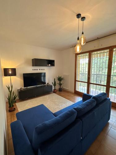 uma sala de estar com um sofá azul e uma televisão de ecrã plano em Camera privata La Mura em La Mura