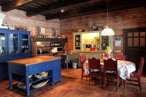 una cocina con armarios azules y una mesa con sillas en Senosios Geguzines ukis en Gegužinė