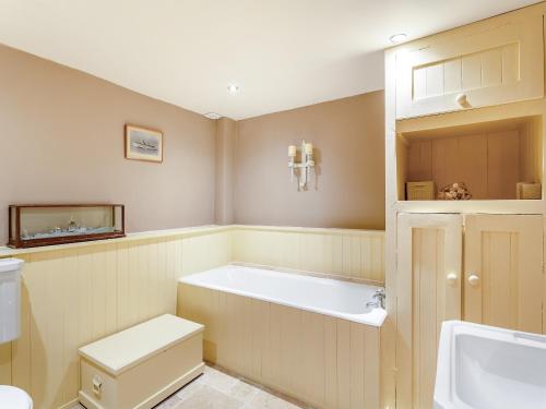 a bathroom with a tub and a toilet and a sink at Holmeside Barn in Grewelthorpe