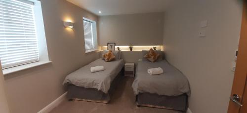 2 camas individuais num quarto com uma janela em Rare luxury Harbourview apartment sleeps 6 em Torquay