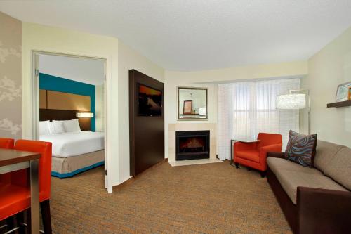 Habitación de hotel con cama y sala de estar. en Residence Inn Colorado Springs South en Colorado Springs