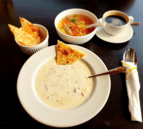 einen Tisch mit einer Schüssel Suppe und einem Teller Essen in der Unterkunft Times Klang Sapan Resort in Ban Sapan