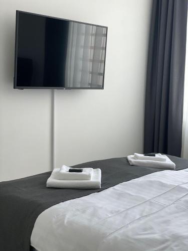 a bedroom with a bed with a flat screen tv on the wall at Morpheus apartmani in Sremska Mitrovica