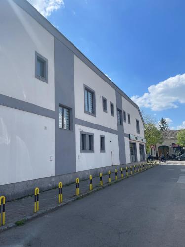 a large white building with yellow barriers in front of it at Morpheus apartmani in Sremska Mitrovica