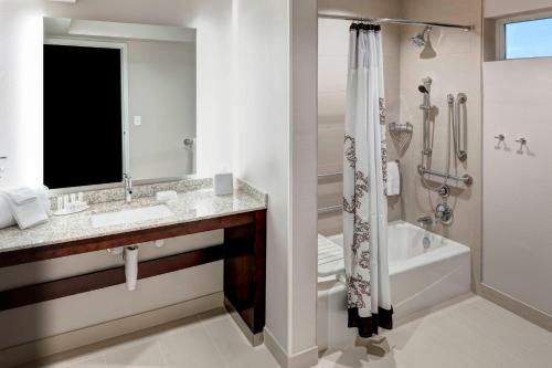 Residence Inn by Marriott Dallas Plano/Richardson في بلانو: حمام مع حوض وحوض استحمام ودش