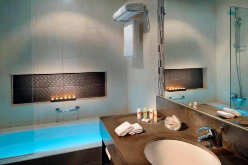La salle de bains est pourvue d'une baignoire, d'un lavabo et d'une douche. dans l'établissement Residence Inn by Marriott Manama Juffair, à Manama