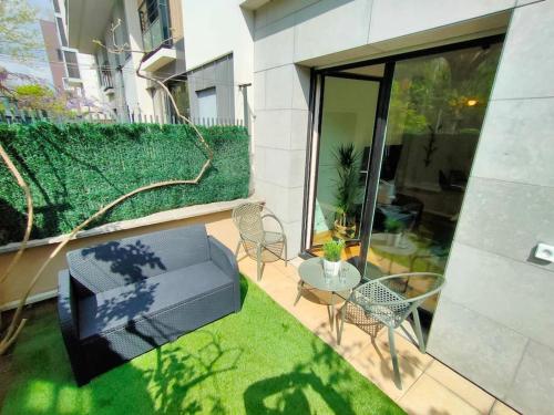 a small patio with a table and chairs and a glass door at Cocon lumineux avec parking et sauna Paris direct in Asnières-sur-Seine