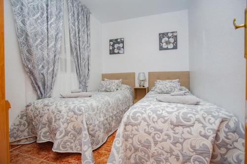 a bedroom with two beds and a window at 139 Lucias Beach Alicante Holiday in Torrevieja