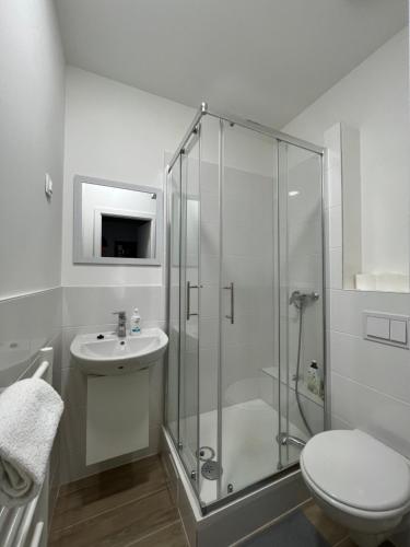 e bagno con doccia, servizi igienici e lavandino. di Noble Studio Apartments a Zagabria