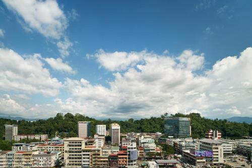 a city with tall buildings and a cloudy sky at Le Meridien Kota Kinabalu in Kota Kinabalu