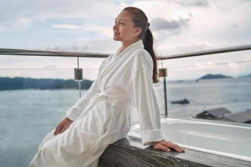 a woman in a white dress sitting on a boat at Le Meridien Kota Kinabalu in Kota Kinabalu