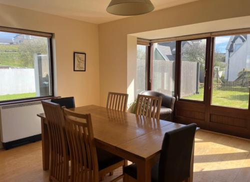 a dining room with a wooden table and chairs at No. 6 Corran Meabh in Lahinch