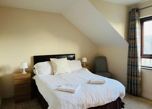 um quarto com uma cama grande com duas toalhas em No. 6 Corran Meabh em Lahinch