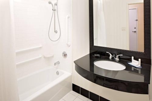 a bathroom with a sink and a tub and a mirror at Fairfield Inn and Suites by Marriott Dallas Mansfield in Mansfield