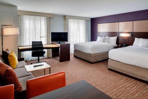 バンガーにあるResidence Inn by Marriott Bangorのベッド2台とソファが備わるホテルルームです。