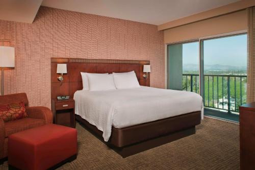 une chambre d'hôtel avec un lit et une chaise dans l'établissement Courtyard Los Angeles Sherman Oaks, à Sherman Oaks