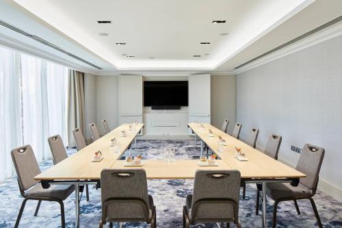 a conference room with a long table and chairs at London Marriott Hotel Canary Wharf in London