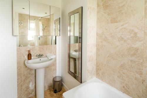 a white bathroom with a sink and a shower at Delightful Stay For 2 in Islington in London
