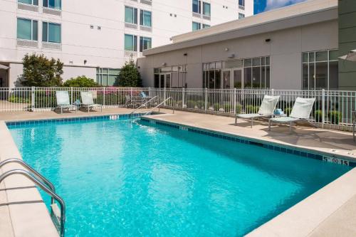 a swimming pool with chairs and a building at SpringHill Suites by Marriott Huntsville Downtown in Huntsville