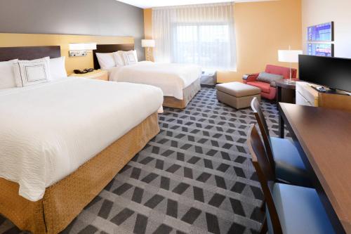 a hotel room with two beds and a desk at TownePlace Suites by Marriott Laredo in Laredo