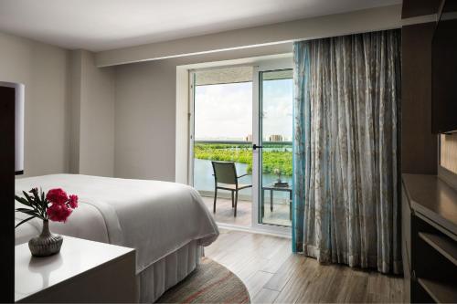 Cette chambre comprend un lit et une grande fenêtre. dans l'établissement The Westin Cancun Resort Villas & Spa, à Cancún