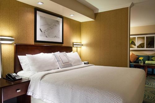 1 dormitorio con 1 cama grande con manta blanca en SpringHill Suites by Marriott Medford, en Medford