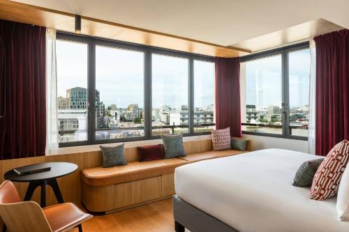 una camera d'albergo con un letto e una grande finestra di Renaissance Bordeaux Hotel a Bordeaux