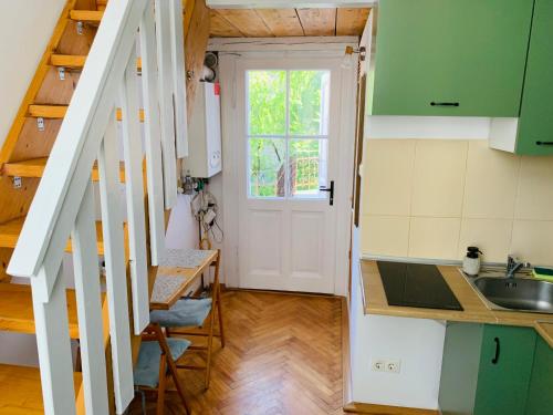 クルジュ・ナポカにあるCentral Cozy Apartmentのキッチン(緑のキャビネット、シンク付)