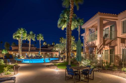 a resort with a pool and palm trees at night at Residence Inn Palm Desert in Palm Desert