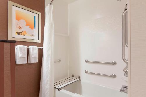 a bathroom with a shower and a white tub at Fairfield Inn & Suites Longview in Longview