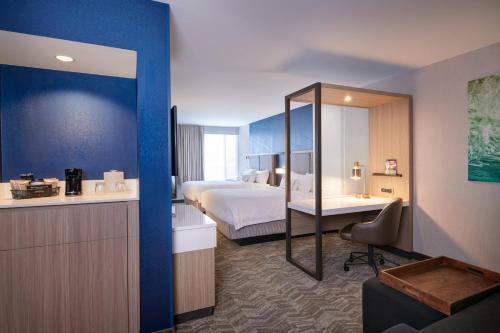 a hotel room with a bed and a mirror at SpringHill Suites by Marriott Detroit Wixom in Wixom