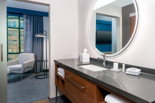 a bathroom with a sink and a mirror at Courtyard by Marriott Atlanta Midtown in Atlanta
