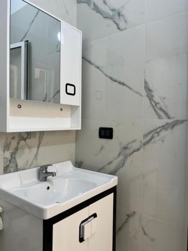 un bagno bianco con lavandino e specchio di Hotel Antik a Golem