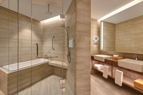 La salle de bains est pourvue d'une baignoire, d'un lavabo et d'une douche. dans l'établissement Courtyard by Marriott Setia Alam, à Setia Alam