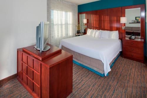 a hotel room with a bed and a flat screen tv at Residence Inn Dover in Dover